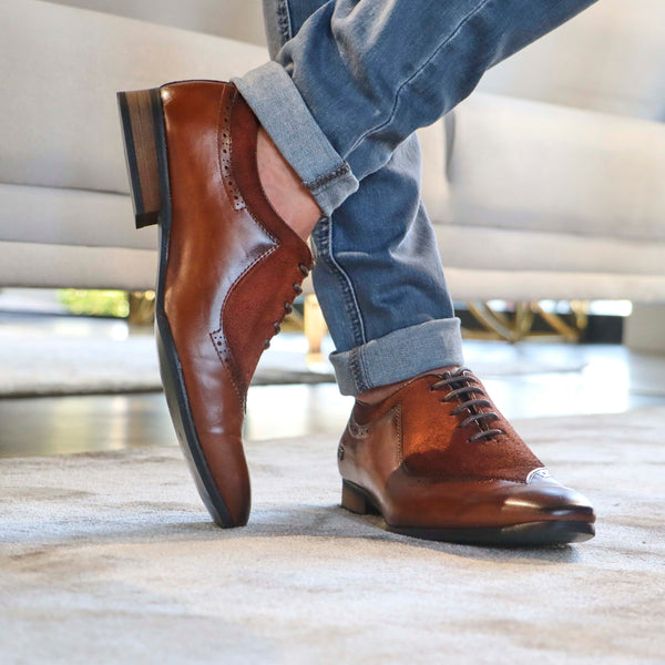 An individual dressed in refined and classic footwear.